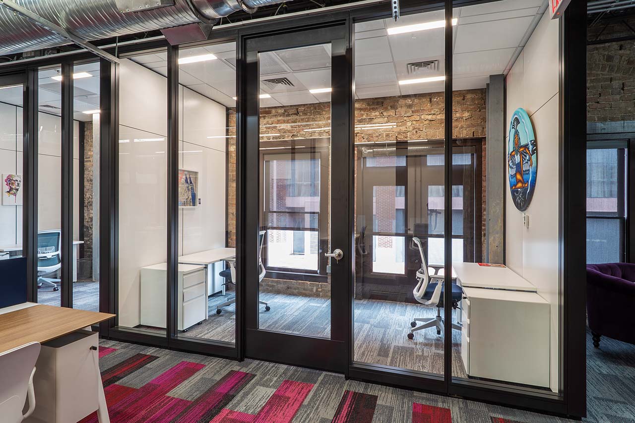 A view of a two person office with art on the walls